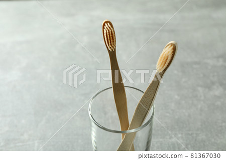 Glass with eco friendly toothbrushes on gray background 81367030