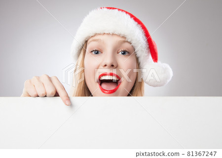 Christmas woman in santa hat pointing empty board Christmas woman in santa hat pointing empty board 81367247