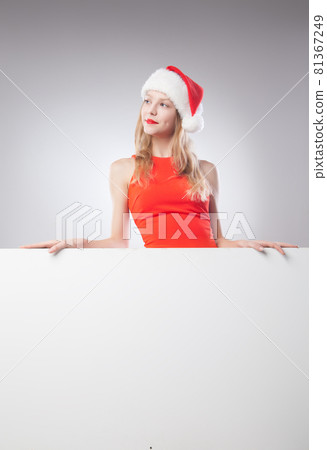 Christmas woman in santa hat holding empty board 81367249