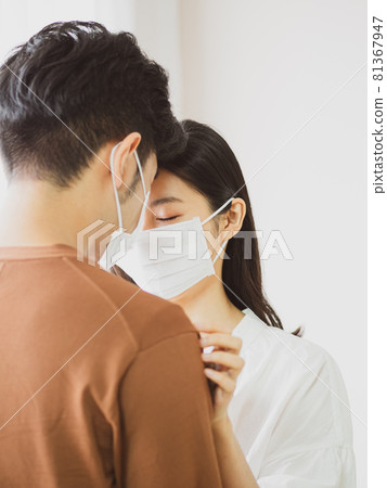 亞洲女人和亞裔男人在家戴外科口罩防止感染新冠肺炎COVID-19 亞洲女人和亞裔男人在家戴外科口罩防止感染新冠肺炎COVID-19 81367947