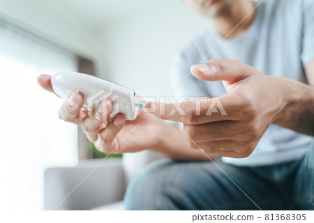 Asian man checking blood sugar level by Digital Glucose meter, Healthcare and Medical, diabetes, glycemia concept 81368305