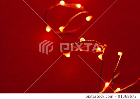 Red background with illuminated lights of garland Red background with illuminated lights of garland 81369672