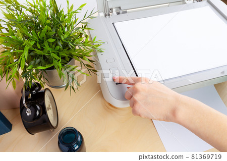 Hands of a woman using a copying machine close up Hands of a woman using a copying machine close up 81369719