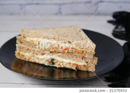 vegetable sandwich on a pate on table . vegetable sandwich on a pate on table . 81370933