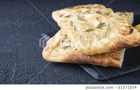 Italian bread - traditional two pieces of focaccia. Focaccia consists of flour, olive oil, water, Fleur de sel, sugar and yeast, topped with rosemary and baked in the oven 81371854