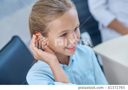 Deaf girl with new sensations in listening apparatus Deaf girl with new sensations in listening apparatus 81372765