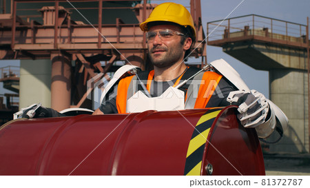 Man in exoskeleton carrying heavy barrel 81372787