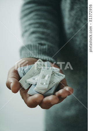 has a bunch of covid-19 tests in his hand has a bunch of covid-19 tests in his hand 81372956