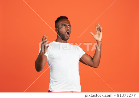 Portrait of African young man in casual clothes isolated on red color studio background. Concept of human emotions, facial expression, youth, feelings, ad. Portrait of African young man in casual clothes isolated on red color studio background. Concept of human emotions, facial expression, youth, feelings, ad. 81373277