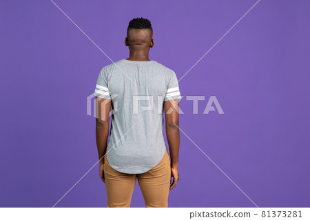 Back view of African-american young man's portrait on purple color studio background. Concept of human emotions, facial expression, youth, feelings, ad. Back view of African-american young man's portrait on purple color studio background. Concept of human emotions, facial expression, youth, feelings, ad. 81373281