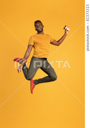 Portrait of African young man in casual clothes isolated on yellow color studio background. Concept of human emotions, facial expression, youth, feelings, ad. Portrait of African young man in casual clothes isolated on yellow color studio background. Concept of human emotions, facial expression, youth, feelings, ad. 81373315