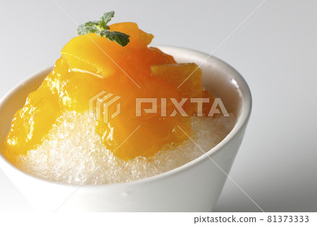 用大量芒果糖漿拍攝的刨冰，白色背景上有果肉 81373333