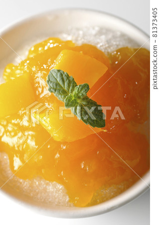 A bird's-eye view of shaved ice with plenty of mango syrup containing pulp on a white background 81373405