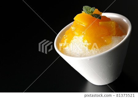 Photographed shaved ice with plenty of mango syrup with pulp on a black background 81373521
