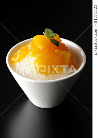 Photographed shaved ice with plenty of mango syrup with pulp on a black background 81373522
