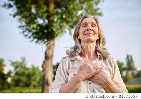 Happy woman folded hands on her chest Happy woman folded hands on her chest 81373557
