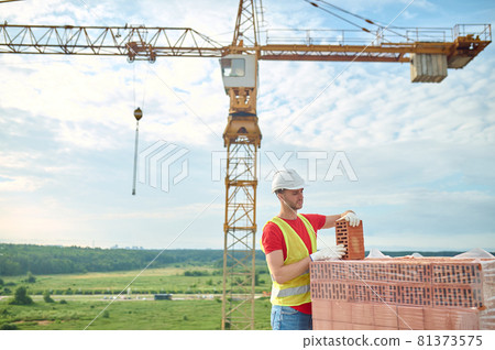 Experienced builder in cotton gloves checking the quality of construction materials Experienced builder in cotton gloves checking the quality of construction materials 81373575