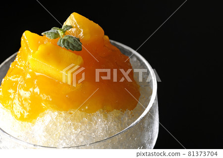 在黑色背景上拍攝了帶有大量芒果糖漿的刨冰和果肉 在黑色背景上拍攝了帶有大量芒果糖漿的刨冰和果肉 81373704