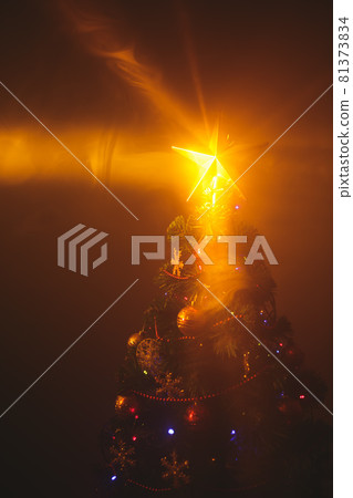Christmas tree with shining star and dense smoke 81373834