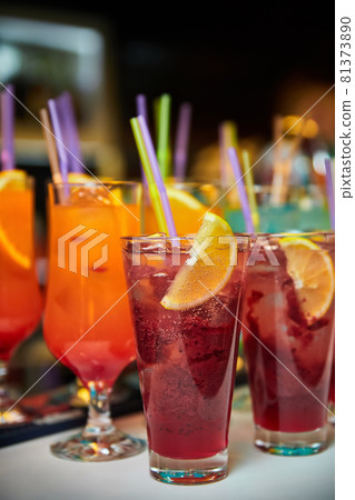 Multicolored alcoholic and non-alcoholic cocktails with ice and straws 81373890