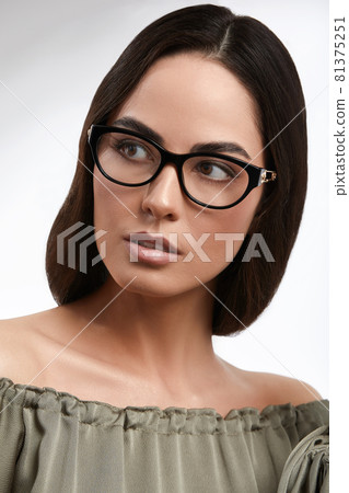 Stylish young brunette in a green dress and glasses, magazine cover, fashion industry, successful business woman. 81375251