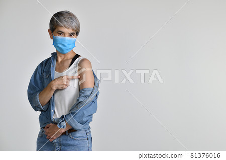 Asian woman vaccinated pointing at plaster bandage on her arm after coronavirus antiviral injection Asian woman vaccinated pointing at plaster bandage on her arm after coronavirus antiviral injection 81376016