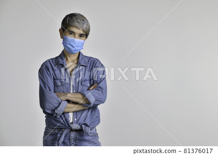 Middle aged Asian woman wearing surgical mask for coronavirus isolated on white background Middle aged Asian woman wearing surgical mask for coronavirus isolated on white background 81376017