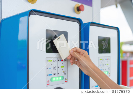 A hand tapping EV charging point card to reader machine. Unlock the station. Electric vehicles battery. Chargeable device or electronic. A hand tapping EV charging point card to reader machine. Unlock the station. Electric vehicles battery. Chargeable device or electronic. 81376570