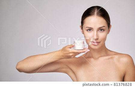 Beautiful Young Woman with Clean Fresh Skin standing over light grey background 81376828