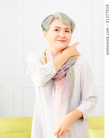 A mature and beautiful gray-haired woman in Asia wears a blank space with a blank space background. 81377918
