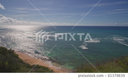 View from above to Diamond Head Beach Park. People swim in the ocean. Yellow sand on the beach on the tropical island of Oahu Hawaii. The turquoise color of the Pacific Ocean water. 81378630