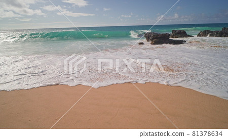 People swim in the ocean. Yellow sand at Sandy Beach on the tropical island of Oahu Hawaii. The turquoise color of the Pacific Ocean water. Steadicam shooting. People swim in the ocean. Yellow sand at Sandy Beach on the tropical island of Oahu Hawaii. The turquoise color of the Pacific Ocean water. Steadicam shooting. 81378634