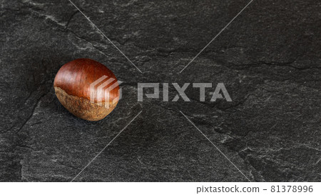 Flat lay photo - detailed close up of chestnut on black stone board. Flat lay photo - detailed close up of chestnut on black stone board. 81378996