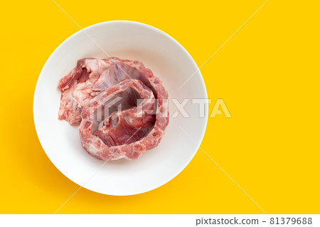 Raw pork ribs in white bowl on yellow background. Raw pork ribs in white bowl on yellow background. 81379688