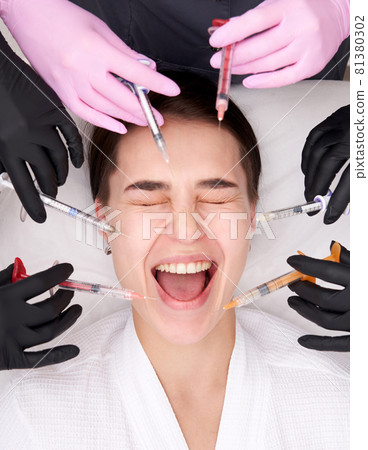 Conceptual beauty and cosmetology image of hands of several doctors holding syringes. Beauty and Cosmetology concept. Cosmetic procedures mesotherapy 81380302