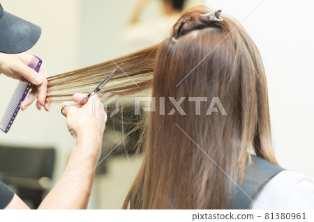 Hands of a stylist who cuts women's hair at a hair salon 81380961