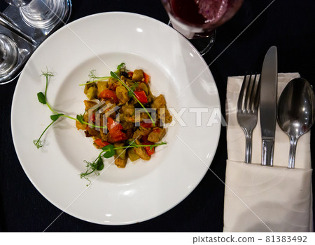 Stewed vegetables on a plate, decorated with herbs Stewed vegetables on a plate, decorated with herbs 81383492