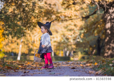 Toddler girl playing in Halloween party in autumn park Toddler girl playing in Halloween party in autumn park 81383598