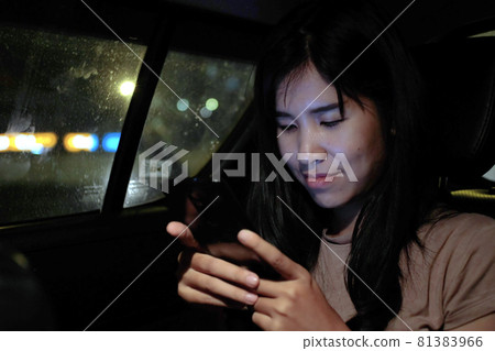 Asian woman sitting in a car using mobile phone, video calling, online app, work from home, working remotely, social distancing, Close up. Asian woman sitting in a car using mobile phone, video calling, online app, work from home, working remotely, social distancing, Close up. 81383966