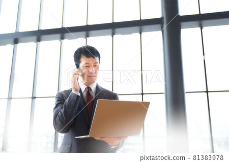 A businessman who talks while looking at a PC A businessman who talks while looking at a PC 81383978