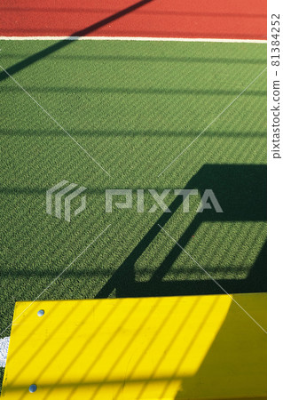 Outdoor sport playground with rubberized ground. Yellow bench on a green sport field. Physical Culture school lesson. Sport background for poster, wallpaper or banner Outdoor sport playground with rubberized ground. Yellow bench on a green sport field. Physical Culture school lesson. Sport background for poster, wallpaper or banner 81384252