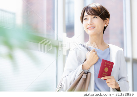 Woman standing by a bright window with a passport 81388989