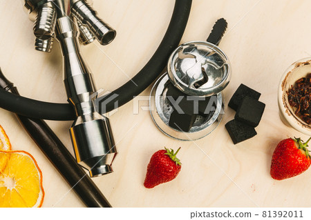 Parts of hookah and fruits on wooden background Parts of hookah and fruits on wooden background 81392011