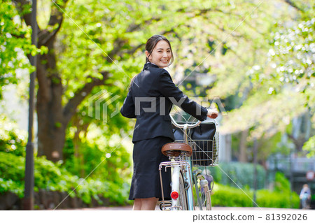 穿著招聘服的年輕女子拉著自行車 穿著招聘服的年輕女子拉著自行車 81392026
