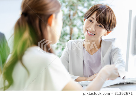 A managerial woman talking face-to-face with her subordinates 81392671