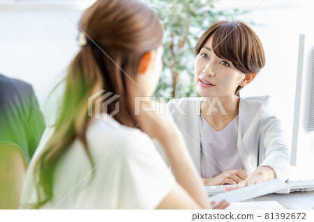 A managerial woman talking face-to-face with her subordinates 81392672