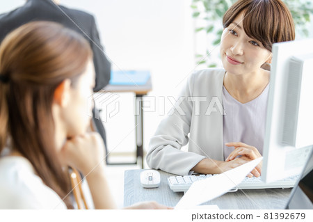 A managerial woman talking face-to-face with her subordinates 81392679