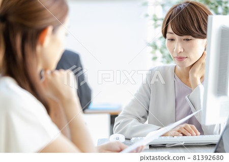 A managerial woman talking face-to-face with her subordinates 81392680