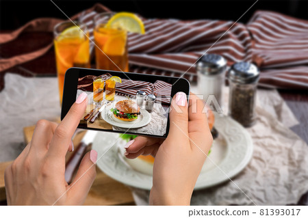 A young woman taking photo of food on smartphone, photographing meal with mobile camera A young woman taking photo of food on smartphone, photographing meal with mobile camera 81393017