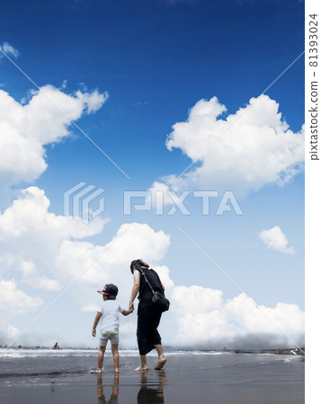 Children and mothers holding hands under the blue sky on the beach 81393024